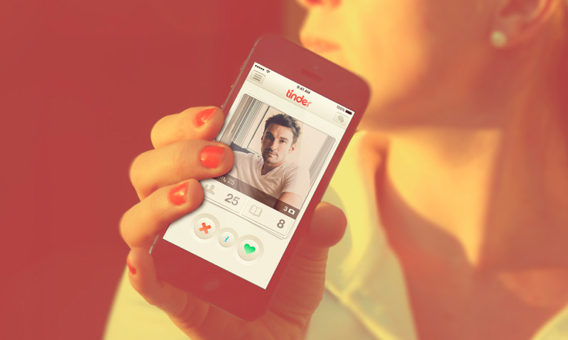 Hand holding smartphone with a tinder app running